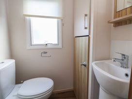 A bathroom with a toilet and sink at A5 Static Caravan in Rhyl