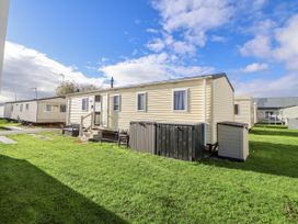 A mobile home with a garden and steps at Chappie's Caravan - Rhyl