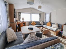 A living room with a sofa and coffee table at Chappie's Caravan - Rhyl