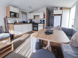 A kitchen with a table and chairs at Chappie's Caravan - Rhyl
