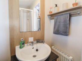 A bathroom with a sink and mirror at Chappie's Caravan - Rhyl