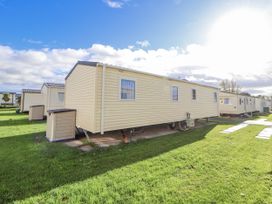 A caravan with grass and a pathway at Chappie's Caravan - Rhyl in Rhyl