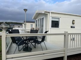 A caravan with chairs on the deck at 5 Rush Grove Caravan in Leven