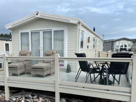 A caravan with a deck featuring seating at 5 Rush Grove Caravan Leven