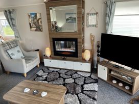 A living room featuring a fireplace and television at 5 Rush Grove Caravan Leven