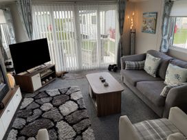 A living room with a sofa and television at 5 Rush Grove Caravan in Leven