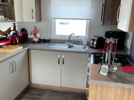 A kitchen with cabinets and appliances at 5 Rush Grove Caravan Leven