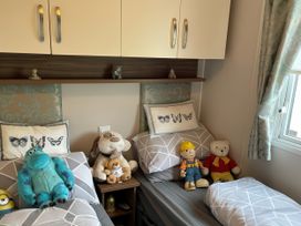 A bedroom with two beds and toys at 5 Rush Grove Caravan in Leven