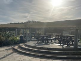 An outdoor seating area with tables and benches at 5 Rush Grove Caravan Leven