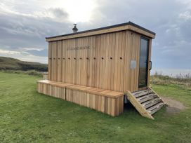 A wooden structure with seating and hooks at 5 Rush Grove Caravan Leven