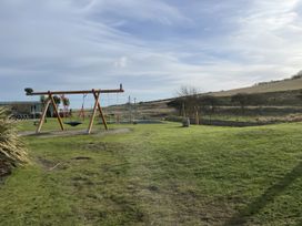 A playground with a swing set on grass at 5 Rush Grove Caravan Leven