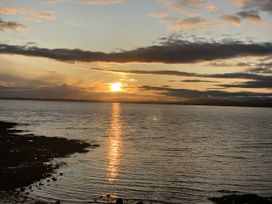 A sunset over the water with clouds in the sky