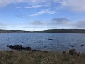 A view of water with rocks and grass at 5 Rush Grove Caravan in Leven