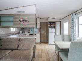 A kitchen with a sofa and dining table at Caravan - 2 Bayside Watchet