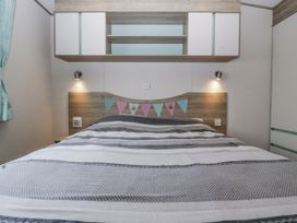 A bedroom with a bed and shelves at Caravan - 2 Bayside in Watchet