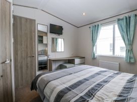 A bedroom with a bed and a desk at Caravan - 2 Bayside in Watchet