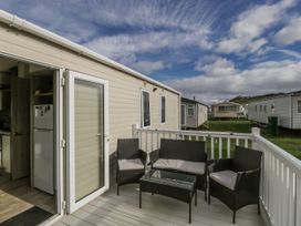 A deck with chairs and a table at Caravan - 2 Bayside Watchet