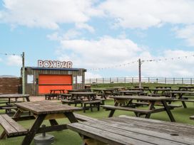 An outdoor seating area with tables near the Box Bar in Watchet