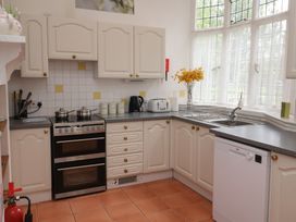 A kitchen with stove, sink, and cupboards at Duke Cottage in Woodbridge