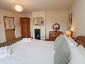 A bedroom with a bed and wardrobe at Duke Cottage in Woodbridge