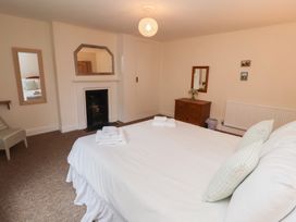 A bedroom with a bed and a mirror at Duke Cottage in Woodbridge