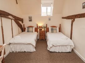 A bedroom with two beds and a bedside table at Duke Cottage in Woodbridge