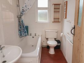 A bathroom with a bathtub, toilet, and sink at Duke Cottage in Woodbridge