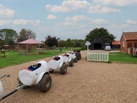 An outdoor area with go-karts and a barn at Duke Cottage in Woodbridge