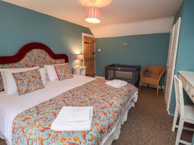 A bedroom with a bed and a crib at Duchess Cottage in Woodbridge