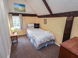 A bedroom with a bed and window at Duchess Cottage in Woodbridge