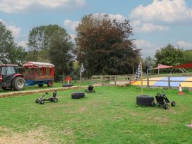 An outdoor play area with go-karts and a tractor at Duchess Cottage in Woodbridge