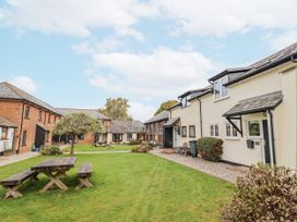 An outdoor area with buildings and a picnic bench at Rushmoor Cottage in Colaton Raleigh