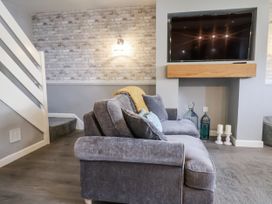 A living room with a sofa and television at Rushmoor Cottage in Colaton Raleigh