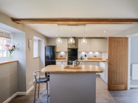 A kitchen with an island and cabinets at Rushmoor Cottage in Colaton Raleigh