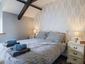 A bedroom with a bed and nightstand at Rushmoor Cottage in Colaton Raleigh