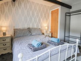 A bedroom with a bed and bedside table at Rushmoor Cottage in Colaton Raleigh