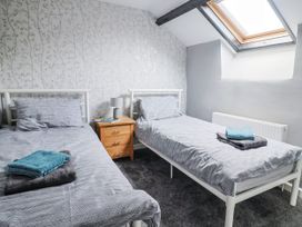 A bedroom with two beds and bedside table at Rushmoor Cottage in Colaton Raleigh