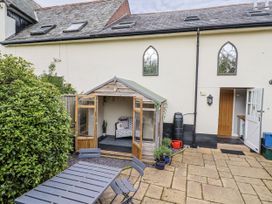 A garden with a shed and outdoor furniture at Rushmoor Cottage in Colaton Raleigh