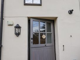 An exterior view of a gray door and light fixture at Rushmoor Cottage Colaton Raleigh