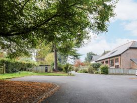 A house with a driveway and trees at Rushmoor Cottage in Colaton Raleigh