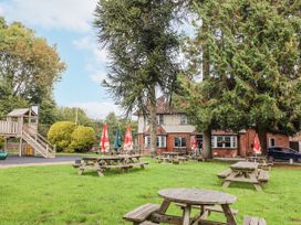 A garden with picnic tables and playground equipment at Rushmoor Cottage in Colaton Raleigh
