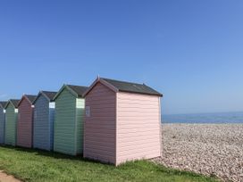 A row of beach huts near the ocean at Rushmoor Cottage in Colaton Raleigh