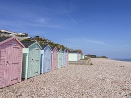 A row of beach huts on a pebble beach at Rushmoor Cottage, Colaton Raleigh