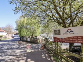 A street view with a cafe sign and trees at Otterton Mill in Colaton Raleigh