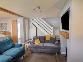 A living room with sofa and television at Rushmoor Cottage in Colaton Raleigh