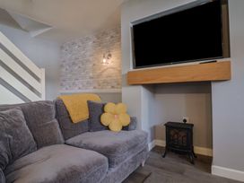 A living room with a sofa and television at Rushmoor Cottage in Colaton Raleigh