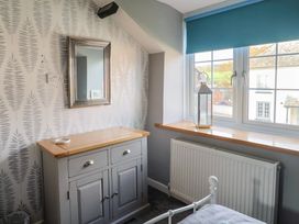 A bedroom with a mirror and chest of drawers at Rushmoor Cottage in Colaton Raleigh