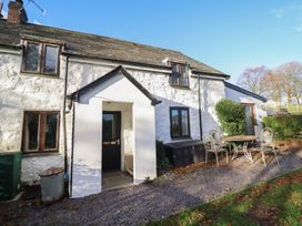 An outdoor view of a house with a table and chairs at 1 Fron Uchaf Parc near Bala
