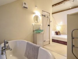 A bathroom with a bathtub and a sink with a mirror at 1 Fron Uchaf in Parc near Bala