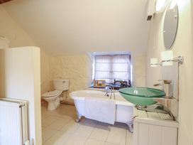 A bathroom with a bathtub, toilet, and sink at 1 Fron Uchaf in Parc near Bala